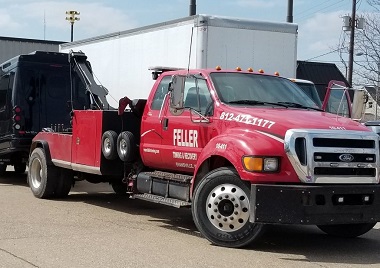 Red tow truck towing van